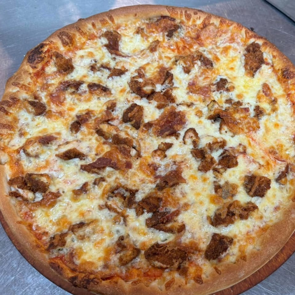 A whole Hudson House of Pizza chicken bacon ranch pizza with a golden crust and melted cheese.